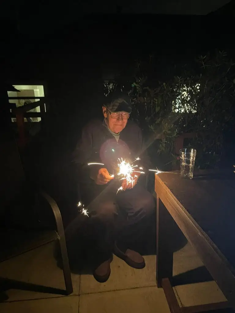 Resident holding a sparkler in garden